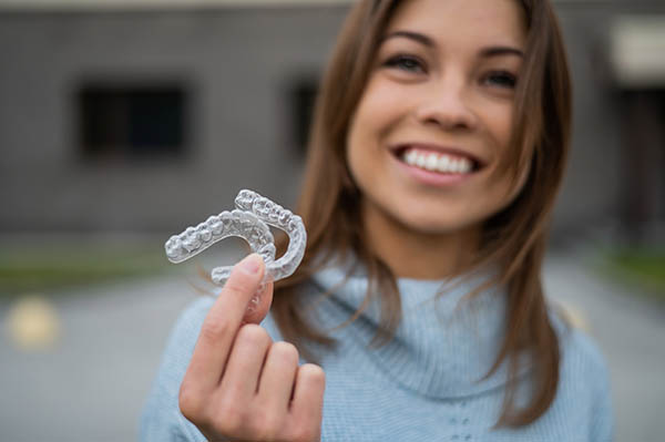 Caucasian,Woman,With,White,Smile,Holding,Transparent,Removable,Retainer.,Bite
